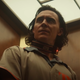 Tom Hiddleston looks incredulous while riding an elevator and wearing an electric collar in Loki.